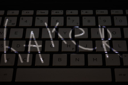 Keyboard for notebook. Beautiful keys with neon violet light. English letters on keyboard. Illuminated keys on hacker keyboard. Device for hacker from all over the worldの写真素材