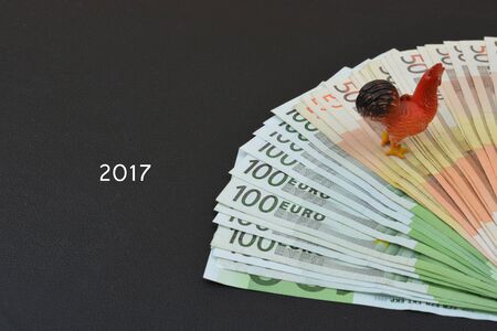 Euros and cock on black background. Cock is symbol of 2017 yearの写真素材
