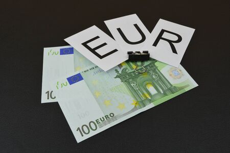 European banknotes with sign "EUR". Euro with clips on black backgroundの写真素材