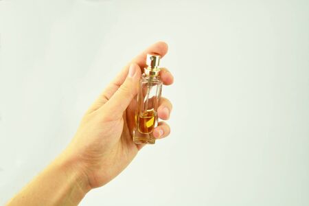A small bottle of perfume in a womans handの写真素材