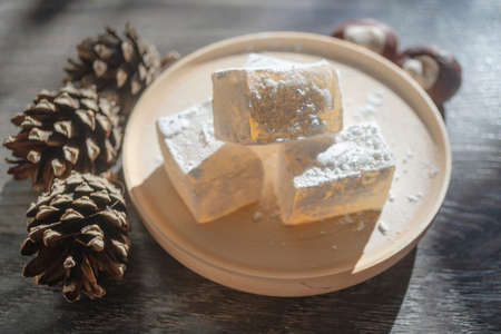 Delicious white turkish delight on wooden dish sprinkled with icing sugar like snow. Oriental pieces...