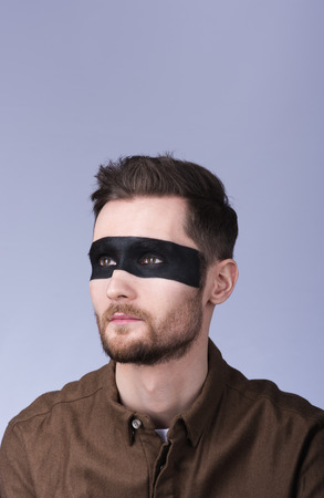 Vertical portrait. Fashionable image. Painted eyes and part of his faceの写真素材