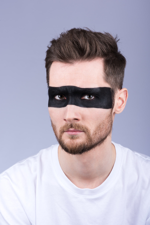 Vertical portrait. Fashionable image. Painted eyes and part of his face. Look at the cameraの写真素材