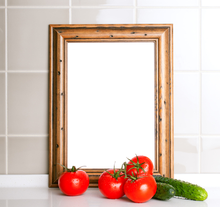 Wooden frame for the menu. Tomatoes and cucumbers in the foreground. Ceramic tile in theの写真素材