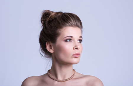 Beauty portrait. Beautiful young woman with luxury decoration. Gentle look. Neutral grey backgroundの写真素材