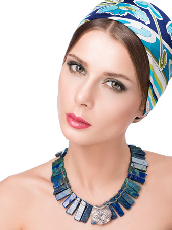 Necklace on the neck and hair with a headscarf. Beauty portrait of beautiful young woman with bright makeup. Isolated on white backgroundの写真素材