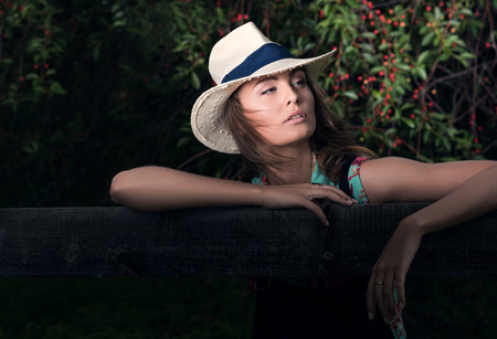 Horizontal portrait in dark tones outdoors. Young attractive woman in the background cherry woodの写真素材