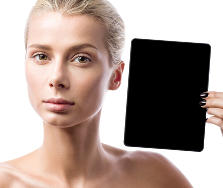 Young beautiful woman shows a black tablet. Portrait isolated on white backgroundの写真素材
