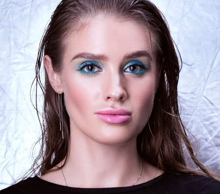 Closeup portrait of beautiful young woman with wet hair. Bright lips and professional make-up. Silver backgroundの写真素材