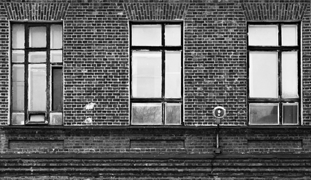 Fragment of the facade of an old brick building. High Windows and textured materials. Black and white stylingの写真素材