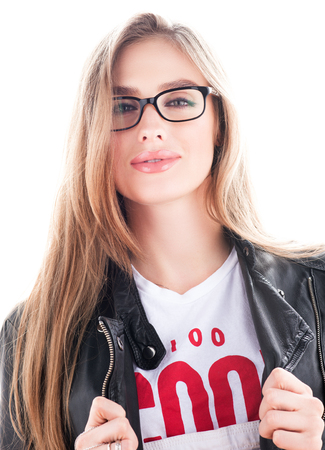 Fashion portrait of stylish young woman in glasses. Hair down. Black leather jacket. Bright white backgroundの写真素材