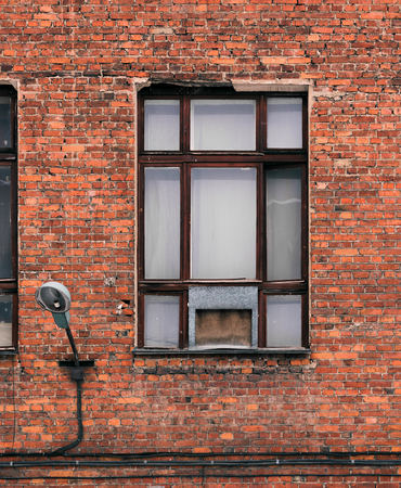 Window on the facade of an old brick building. Loft-style architectural fragmentの写真素材
