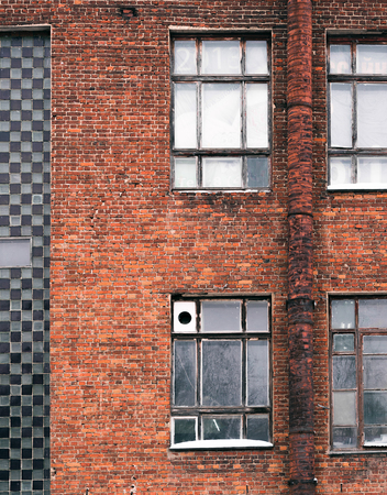 Fragment of the facade of the old building. Windows and brick wallsの写真素材