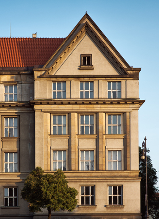 The European facade of the building. The historical centre of Prague. Tile roof, trees. Cloudless blue skyの写真素材