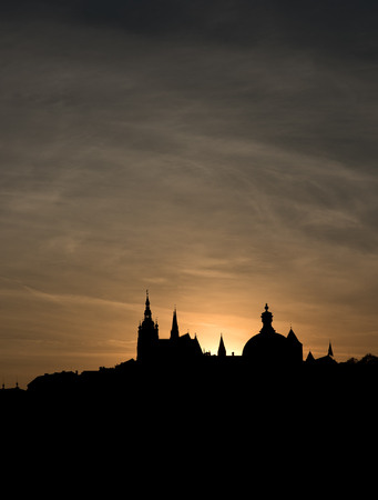 The outline of the old town houses, cathedrals and churches on sunset sky background. The historical centre of Prague. The European urban landscapeの写真素材
