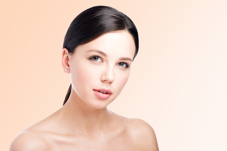 Beauty portrait of a beautiful young woman. Tender look. Perfect makeup. Lips. Perfect skin. Light backgroundの写真素材