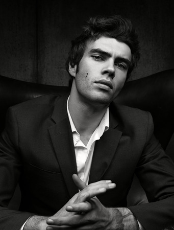 Black and white portrait of confident man in jacket and shirt. Dark backgroundの写真素材