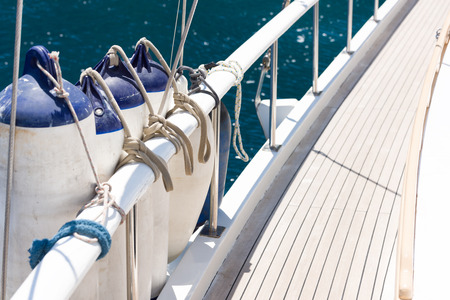 Mooring fenders tied to the railing on the boat. The elements of the vehicle. The background sea...