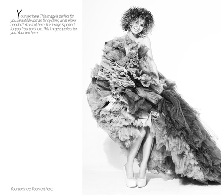 Contrast black and white portrait of sexy youngl woman posing in long dress on the white background of the wall. The texture of the dress and style in fashion. Free space for text placingの写真素材