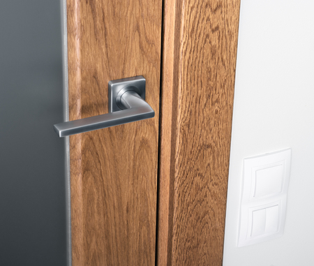 Close-up of door handle on glass door with glass. White switches on the wall. Interior elementの写真素材