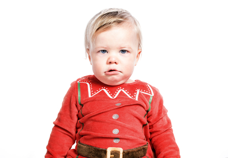 Sad kid dressed as Santa Christmas boy. One isolated on white backgroundの写真素材