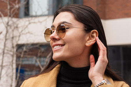 Close-up portrait of a beautiful young girl in sunglasses outdoorsの写真素材
