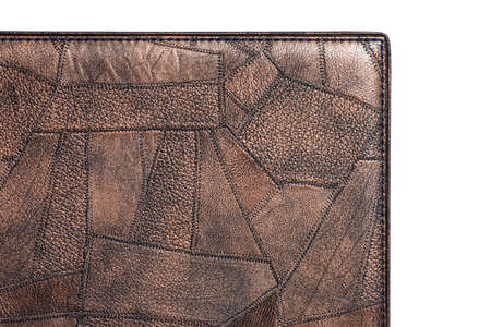 Brown fine polygon-textured leather. Close-up edge isolated at white background.の写真素材