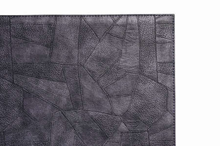 Gray fine polygon-textured leather. Close-up edge isolated at white background.の写真素材