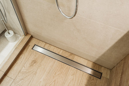 Modern shower drainer in glass cabin with wooden effect walls and floor.の写真素材