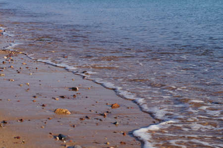 Sea waves and foam on the sand beachの写真素材
