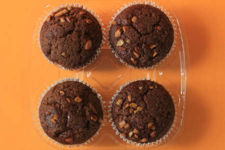 Chocolate muffin isolated on color background. Delicious chocolate muffin with nuts.の写真素材