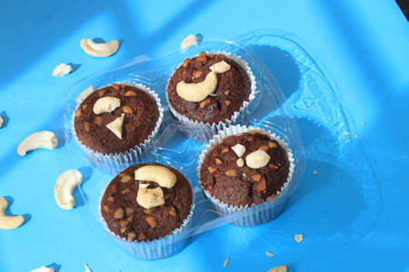 Chocolate muffin isolated on color background. Delicious chocolate muffin with nuts.の写真素材