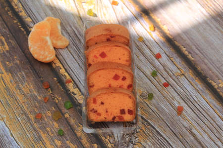 Homemade tutti frutti candied fruit sponge cake on table and colorful background for Christmasの写真素材
