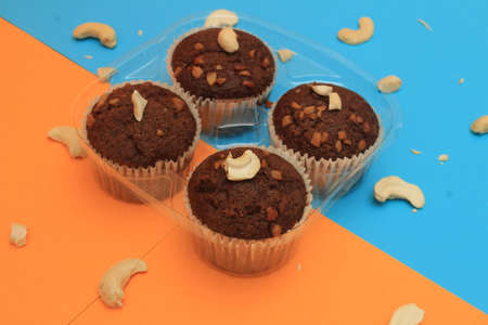 Chocolate muffin isolated on color background. Delicious chocolate muffin with nuts.の写真素材