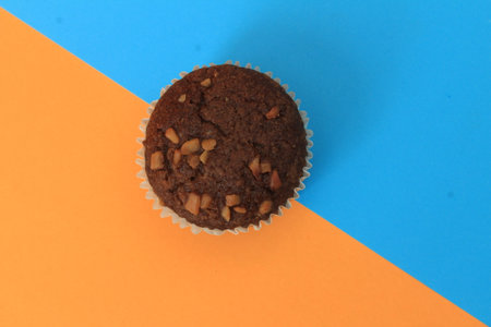 Chocolate muffin isolated on color background. Delicious chocolate muffin with nuts.の写真素材