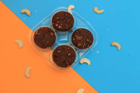 Chocolate muffin isolated on color background. Delicious chocolate muffin with nuts.の写真素材