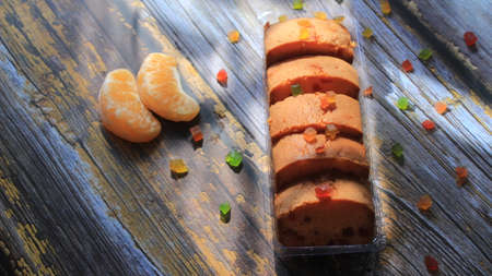 Homemade tutti frutti candied fruit sponge cake on table and colorful background for Christmasの写真素材