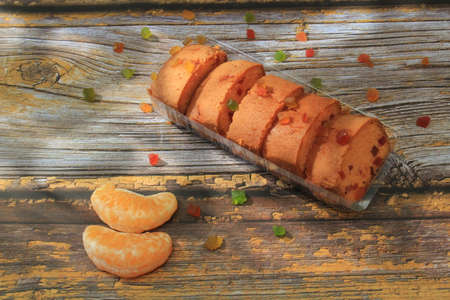 Homemade tutti frutti candied fruit sponge cake on table and colorful background for Christmasの写真素材
