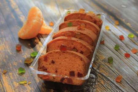 Homemade tutti frutti candied fruit sponge cake on table and colorful background for Christmasの写真素材
