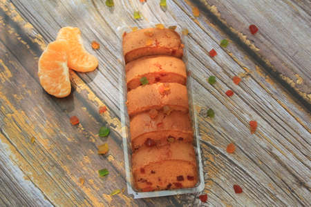 Sweet cake with tutti frutti sprinkles on top on the wooden table white background.の写真素材