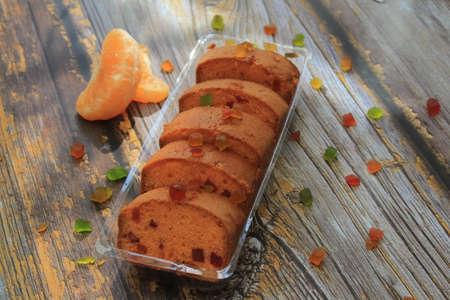 Sweet cake with tutti frutti sprinkles on top on the wooden table white background.の写真素材