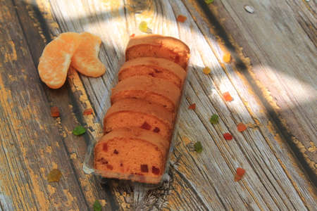 Homemade tutti frutti candied fruit sponge cake on table and colorful background for Christmasの写真素材
