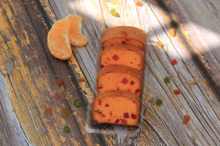 Homemade tutti frutti candied fruit sponge cake on table and colorful background for Christmasの写真素材