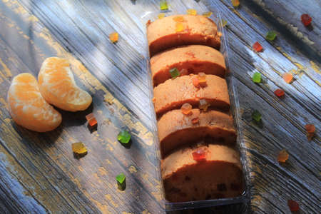 Sweet cake with tutti frutti sprinkles on top on the wooden table white background.の写真素材