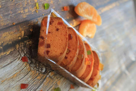 Homemade tutti frutti candied fruit sponge cake on table and colorful background for Christmasの写真素材
