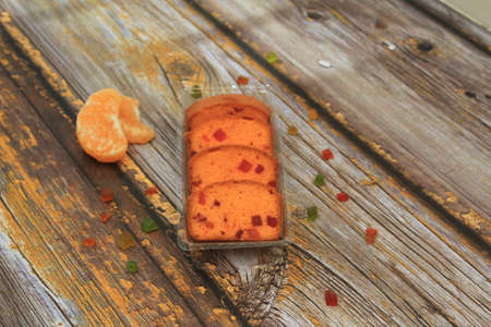 Homemade tutti frutti candied fruit sponge cake on table and colorful background for Christmasの写真素材