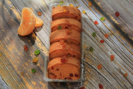 Homemade tutti frutti candied fruit sponge cake on table and colorful background for Christmasの写真素材