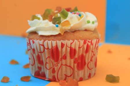 Sweet cake with tutti frutti sprinkles on top on the color background.の写真素材