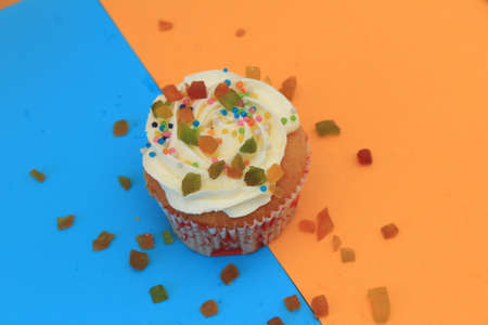 Sweet cake with tutti frutti sprinkles on top on the color background.の写真素材