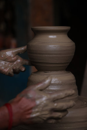 The potter works on a pottery wheel to made of soft colored clay, retro style toned Clay pots with hand and equipmentの写真素材
